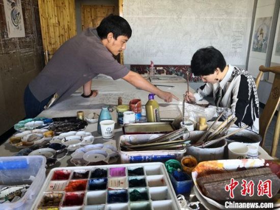 圖為2020年8月下旬,敦煌“80后”畫家張杰龍(左)在為云南麗江“學生”莫北講解敦煌壁畫的繪畫技巧。 馮志軍 攝 圖為2020年8月下旬,敦煌“80后”畫家張杰龍(左)在為云南麗江“學生”莫北講解敦煌壁畫的繪畫技巧。 馮志軍 攝