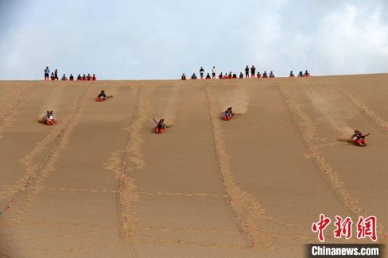6月13日,敦煌鳴沙山月牙泉景區舉辦滑沙比賽。 張曉亮 攝 6月13日,敦煌鳴沙山月牙泉景區舉辦滑沙比賽。 張曉亮 攝