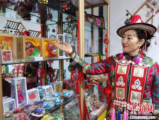 圖為身著民族服飾的隴原巧手展示手工藝品。(資料圖) 徐雪 攝