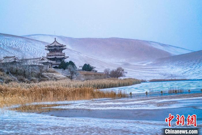 2021年11月28日，雪落鳴沙山月牙泉景區?！⊥醣筱y 攝