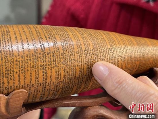 圖為長(zhǎng)約二十公分的長(zhǎng)條葫蘆雕刻佛教經(jīng)文作品。 張婧 攝 圖為長(zhǎng)約二十公分的長(zhǎng)條葫蘆雕刻佛教經(jīng)文作品。 張婧 攝