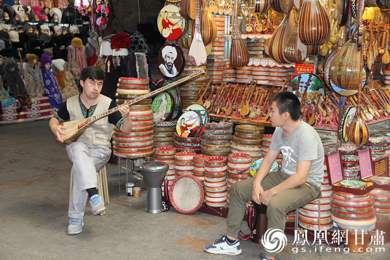 烏魯木齊二道橋巴扎內,店主正在向客人展示樂器。楊文遠 攝