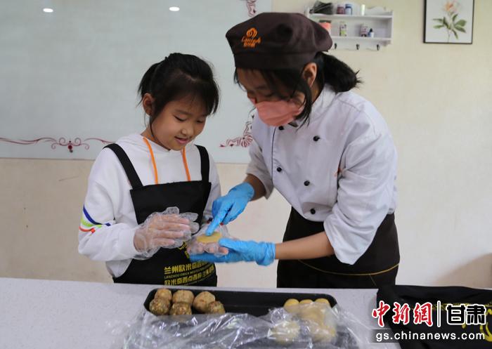 圖為在甘臺胞小朋友在工作人員指導(dǎo)下制作月餅。九美旦增 攝 圖為在甘臺胞小朋友在工作人員指導(dǎo)下制作月餅。九美旦增 攝