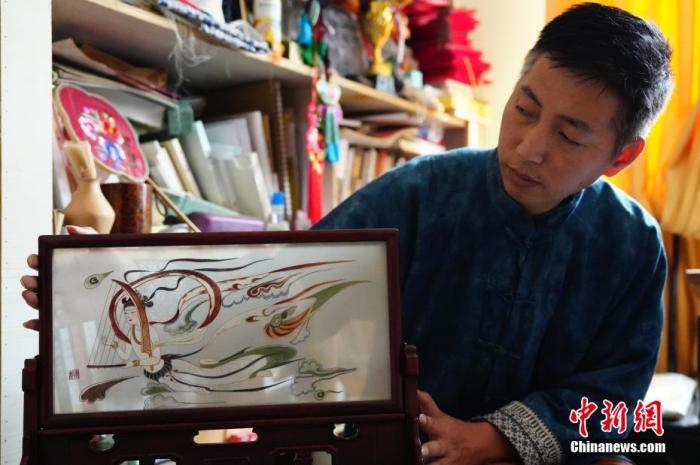 圖為劉云帆展示敦煌元素的刺繡作品。 中新社發(fā) 謝秉錫 攝 圖為劉云帆展示敦煌元素的刺繡作品。 中新社發(fā) 謝秉錫 攝