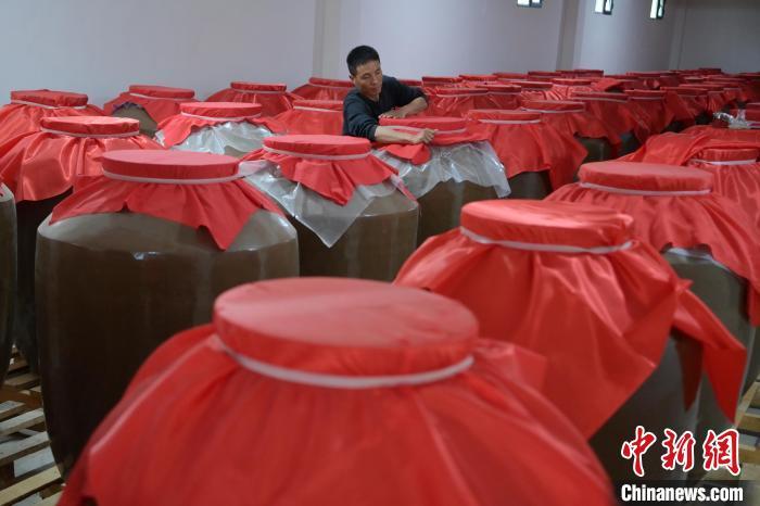 圖為5月10日,工作人員在儲(chǔ)酒庫檢查酒缸密封性。九美旦增 攝